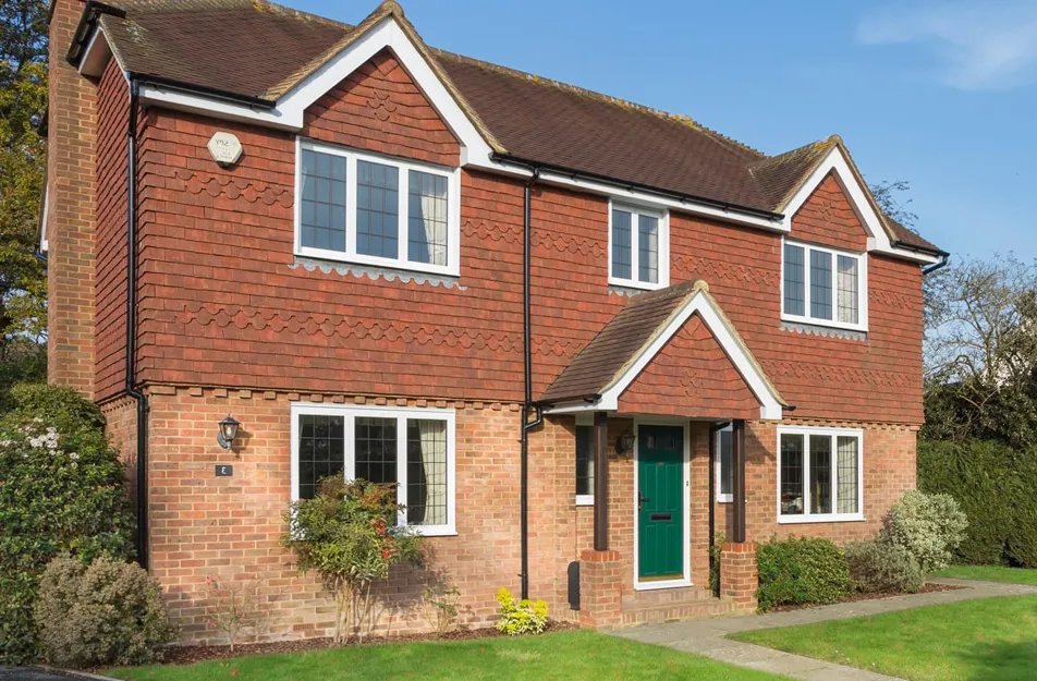 Brick house with terracotta roof and white windows