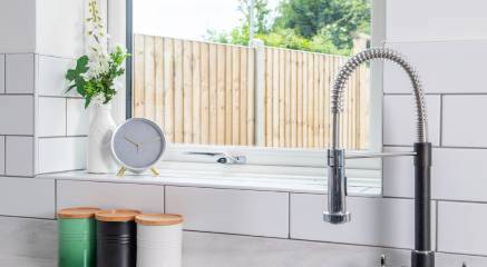 Modern kitchen with a white uPVC window looking out into garden