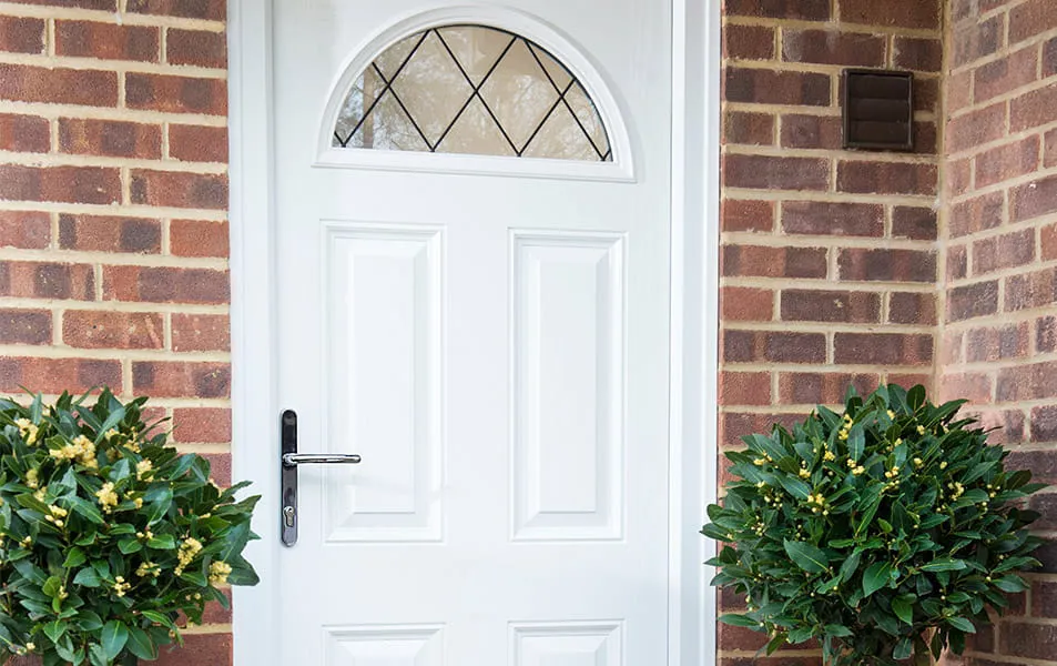 White door with arch top and brick wall