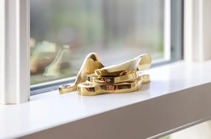 Gold window fastener on white Everest conservatory window