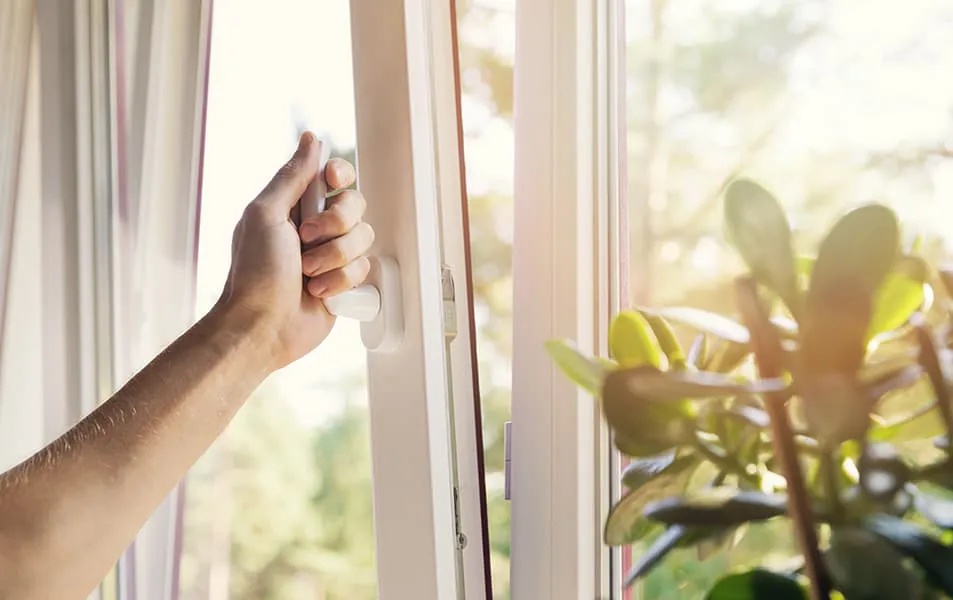 Hand opening a white window