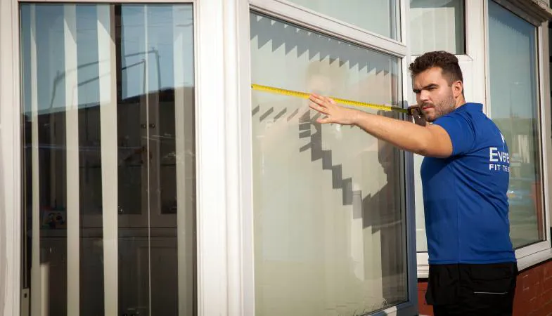 Person measuring Everest conservatory window with tape measure