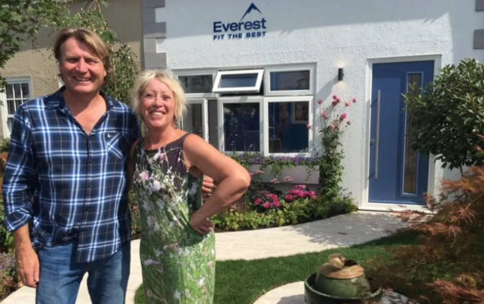 Couple in front of Everest home with blue door