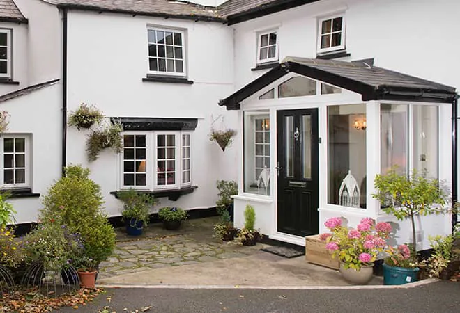 White house with black Everest conservatory and door