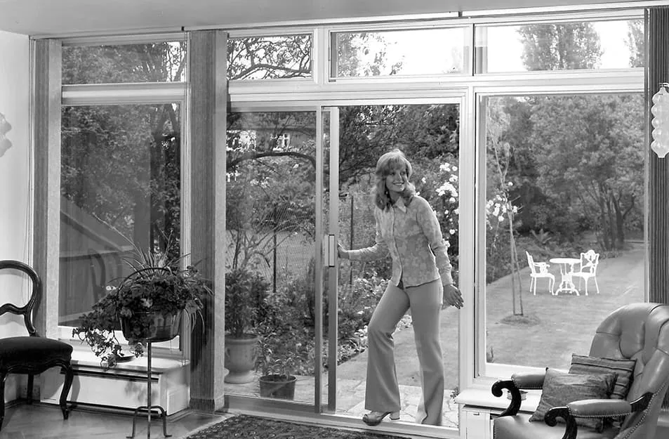 Woman opening Everest conservatory sliding glass doors