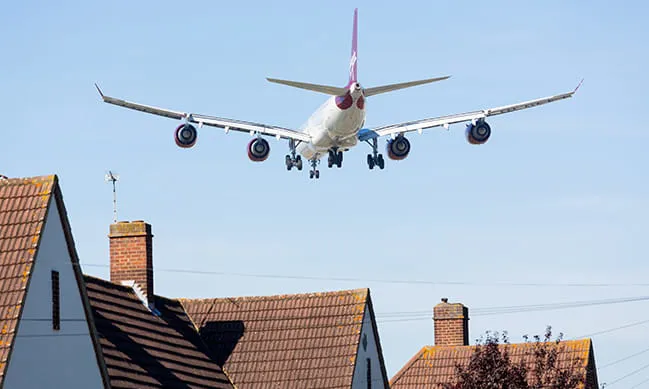 Airplane landing near houses