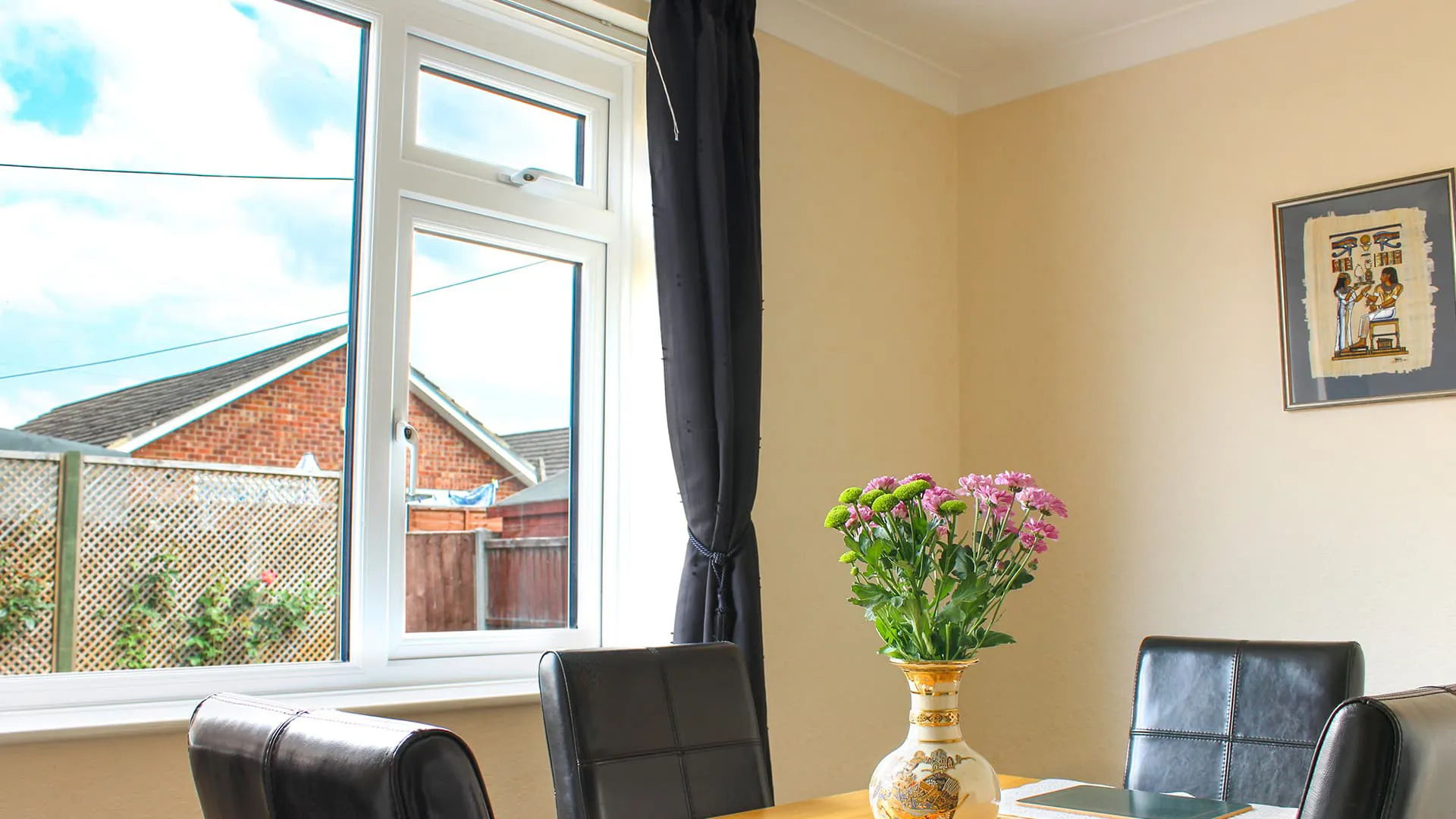 White window with black curtains in a dining room