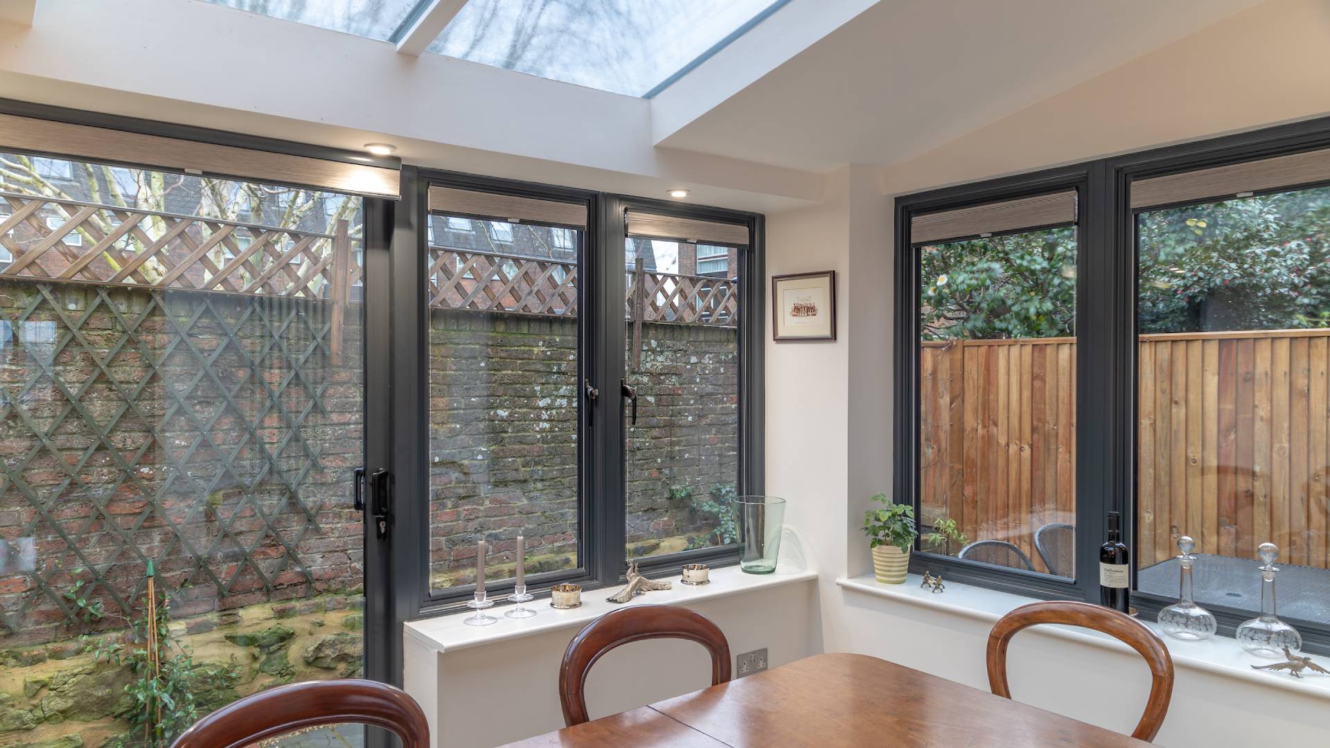 Everest conservatory with dark gray windows and wooden fence