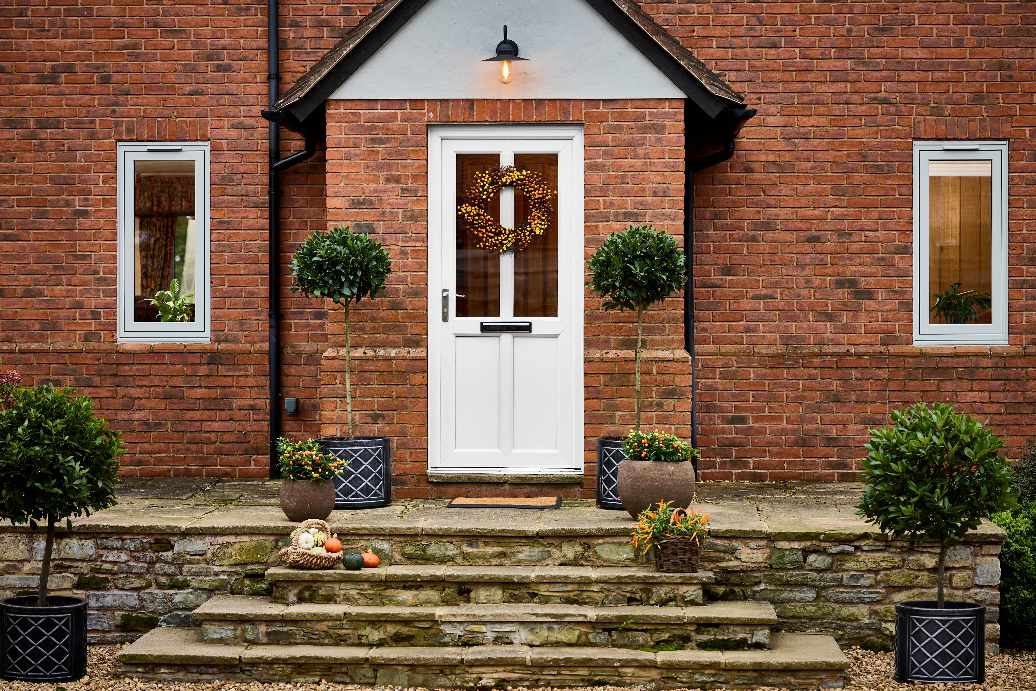 uPVC white front door with 2 glazing panels dressed with an autumn wreath