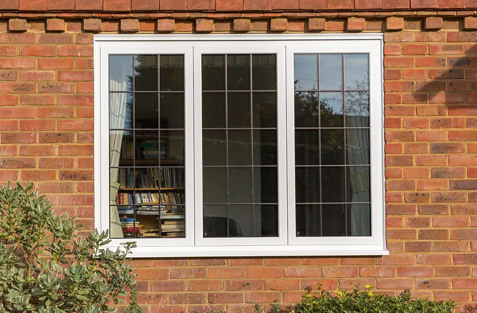 White window with leaded glass on brick wall