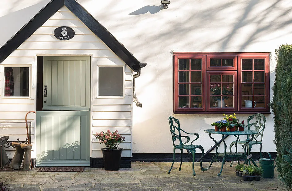 Pale green door with a red window on a light-cream coloured house