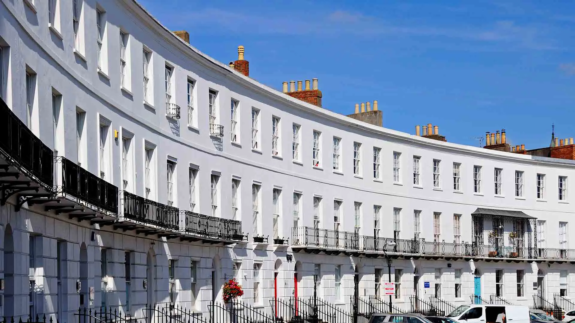 White curved building facade with many windows and balconies