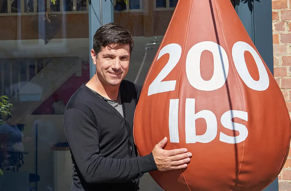 Man holding large 200 lbs terracotta weight