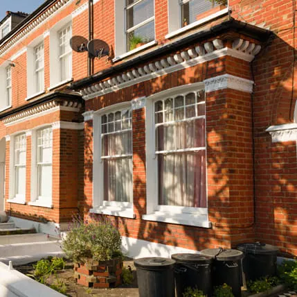 Row of red brick houses with white trim and windows