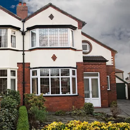 White framed bay windows on a red brick house