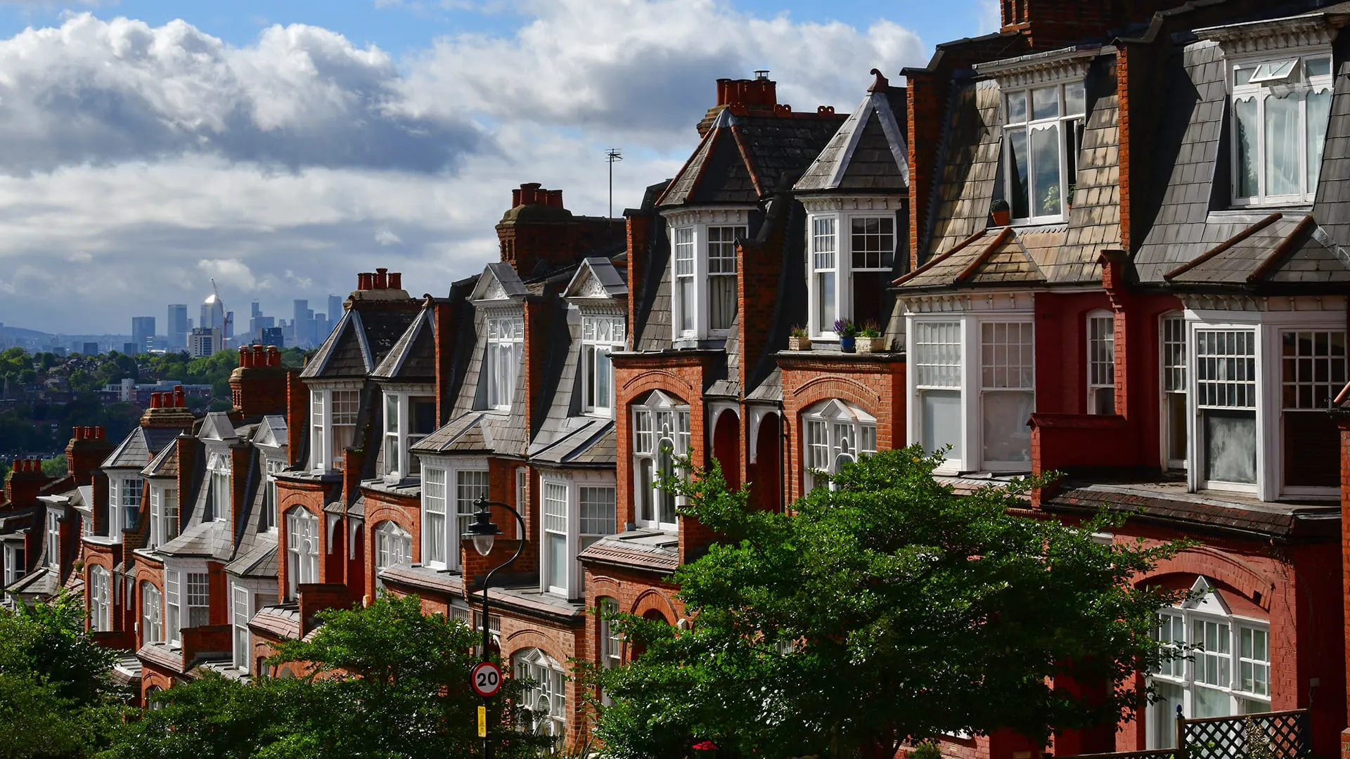 Row of red brick houses with gray roofs and white windows