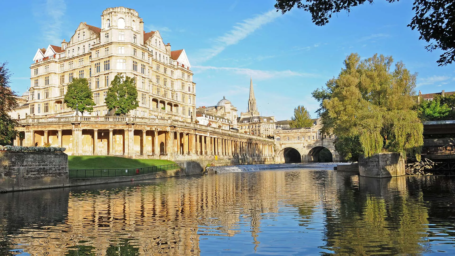 Stone buildings and bridge reflecting in river water