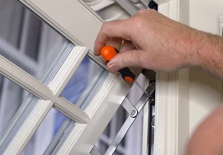 Hand using screwdriver to adjust Everest conservatory window