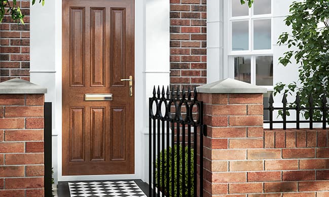 Wooden front door with black metal gate and brick wall