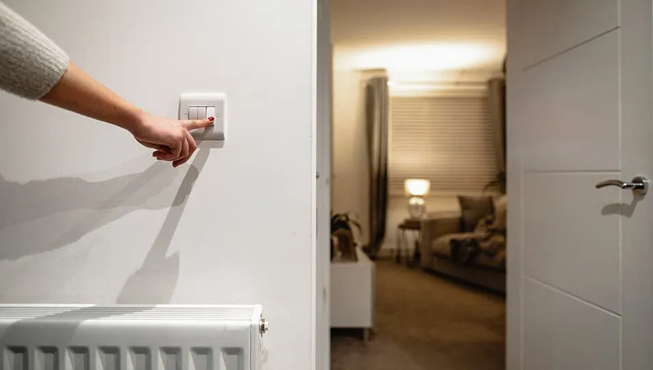 Hand turning on a white light switch