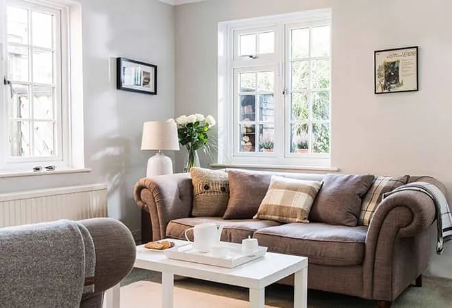 Light beige painted walls with a white Everest conservatory double window and a brown sofa