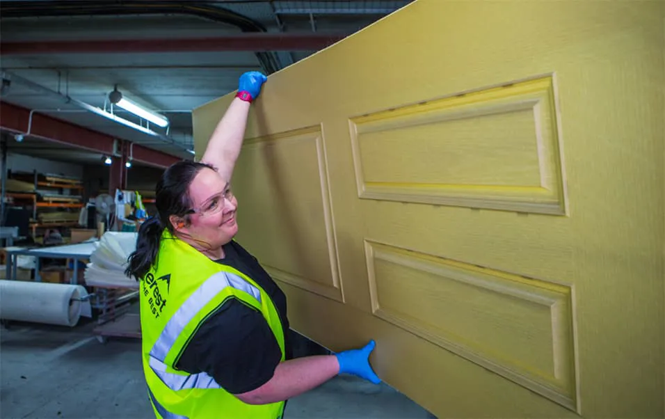 Worker holding a light yellow Everest door