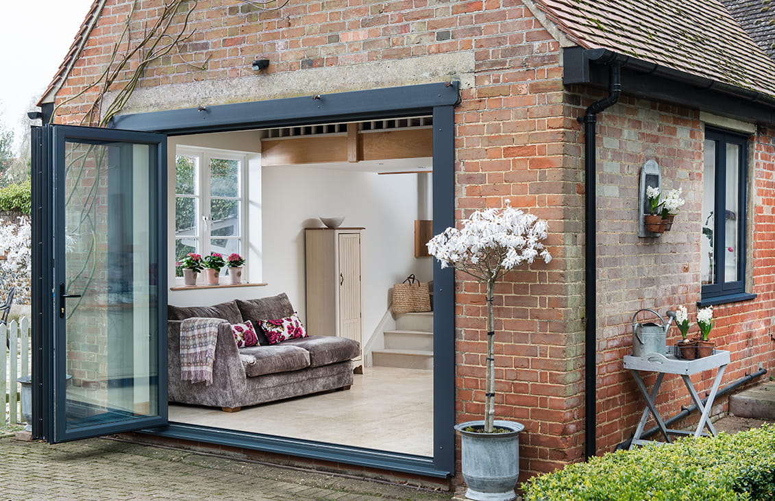 Everest conservatory with grey bi-fold doors and brick walls