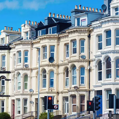 Row of light beige buildings with arched windows