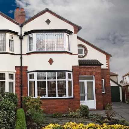 White bay windowed house with red brick facade
